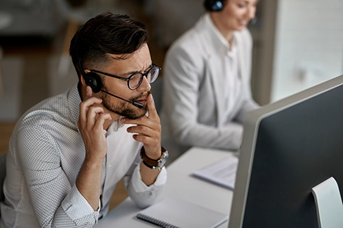 concentrated-call-center-agent-talking-with-customer-while-working-office copy